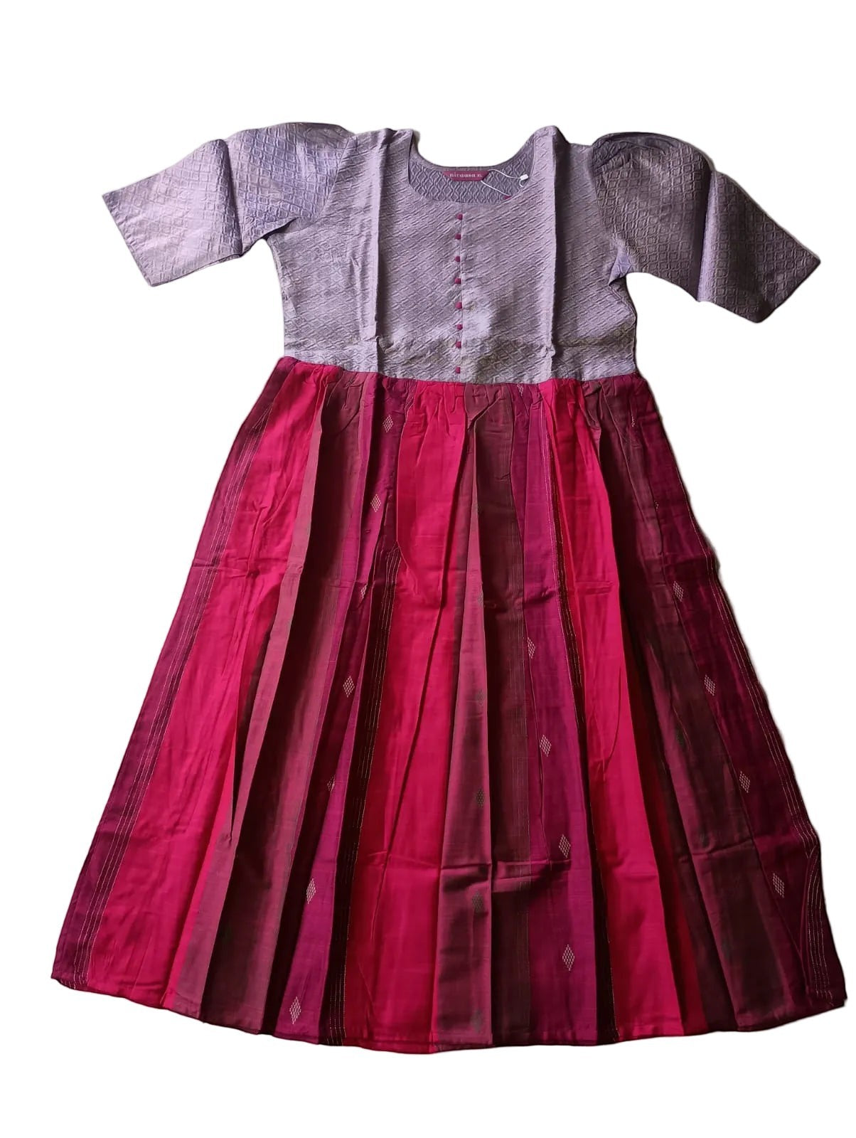Two-piece outfit with a purple top and red skirt on a light gray surface.