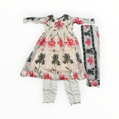kidshe white 3-piece Anarkali suit with pink and grey floral print, pom-pom trim, and white pants.